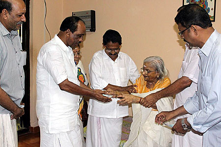 Vallyamma Thampuram of Kochi royal family giving present to Minister K. Babu